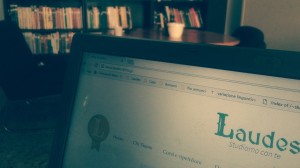 Computer collegato al sito di Laudes con una libreria sullo sfondo